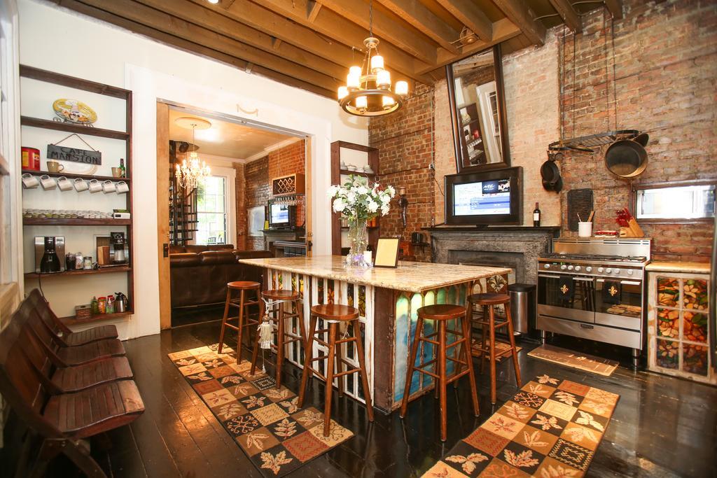 A kitchen nook with a central island, stainless steel appliances, and exposed brick walls.